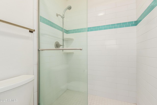 bathroom featuring a stall shower and toilet