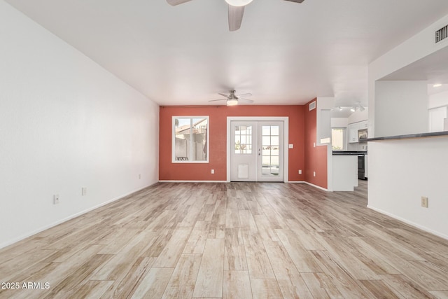 unfurnished living room featuring french doors, visible vents, ceiling fan, and light wood-style flooring