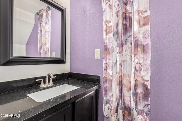 bathroom featuring a textured wall and vanity