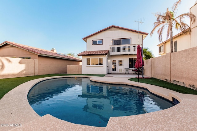 rear view of property featuring a patio, a fenced backyard, and a balcony