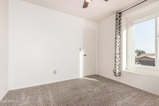 carpeted empty room featuring ceiling fan and baseboards