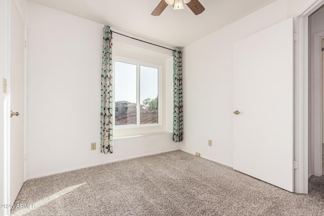 carpeted spare room featuring a ceiling fan