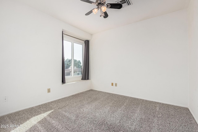 unfurnished room with carpet, visible vents, and ceiling fan