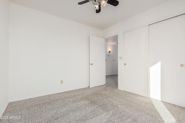 unfurnished bedroom featuring carpet, a ceiling fan, and a closet