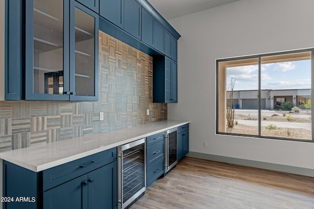 kitchen featuring backsplash, light hardwood / wood-style flooring, wine cooler, and a wealth of natural light