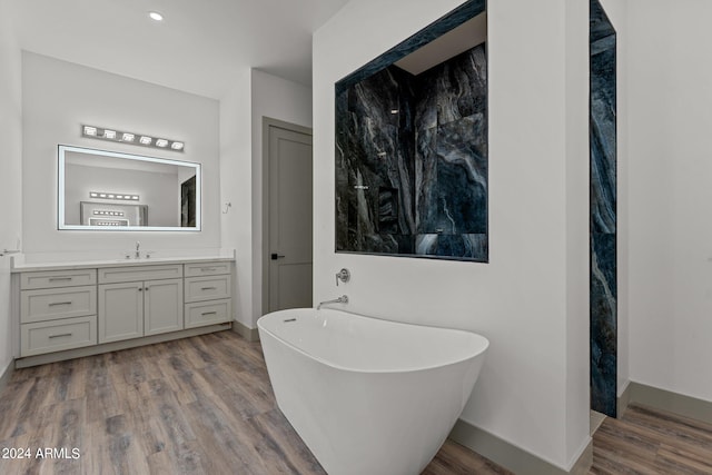 bathroom featuring hardwood / wood-style flooring, vanity, and a bathtub