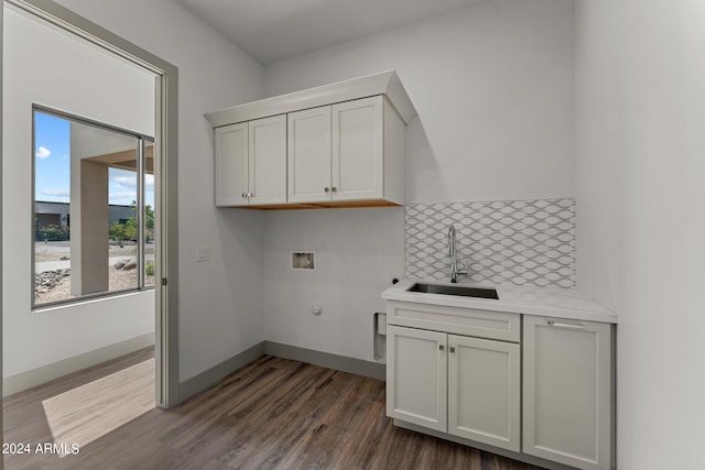 laundry area with sink, dark hardwood / wood-style flooring, washer hookup, and cabinets