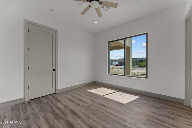 empty room with ceiling fan and hardwood / wood-style flooring