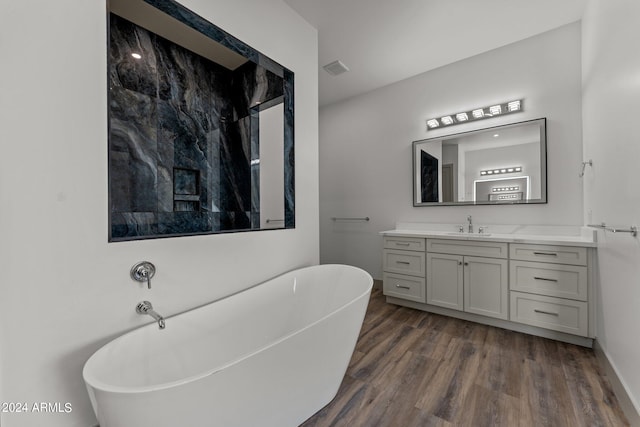 bathroom with vanity, hardwood / wood-style floors, and a washtub