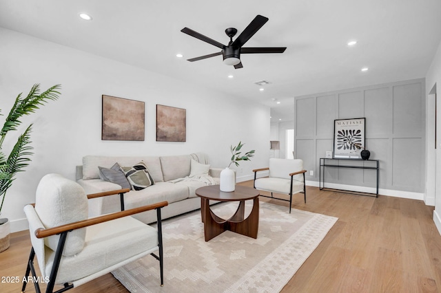 living area with light wood finished floors, recessed lighting, a ceiling fan, and baseboards