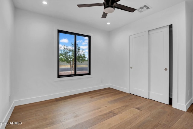 unfurnished bedroom featuring wood finished floors, baseboards, recessed lighting, a closet, and a ceiling fan