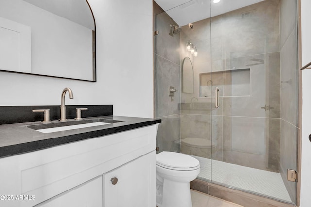 full bath with toilet, a stall shower, vanity, and tile patterned flooring