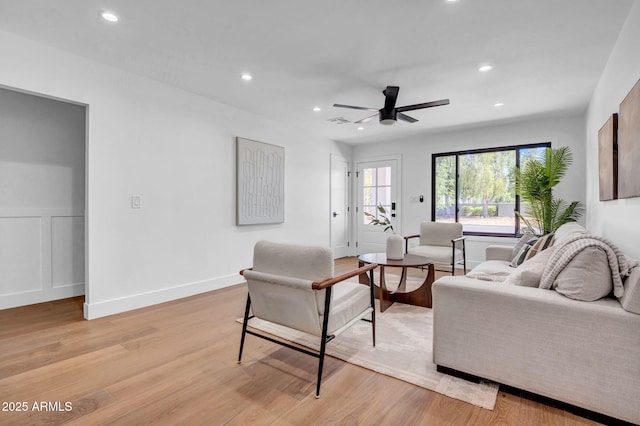 living area with light wood-style floors, recessed lighting, a ceiling fan, and baseboards