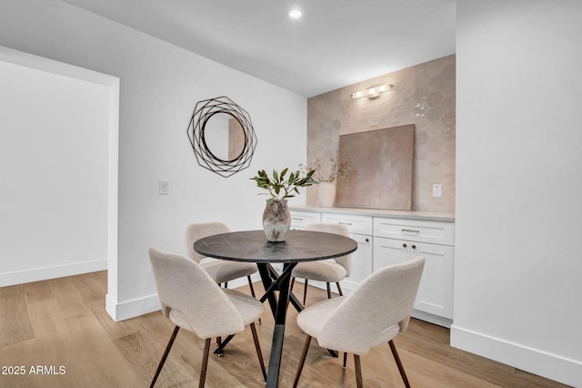 dining room with baseboards, light wood-style flooring, and recessed lighting