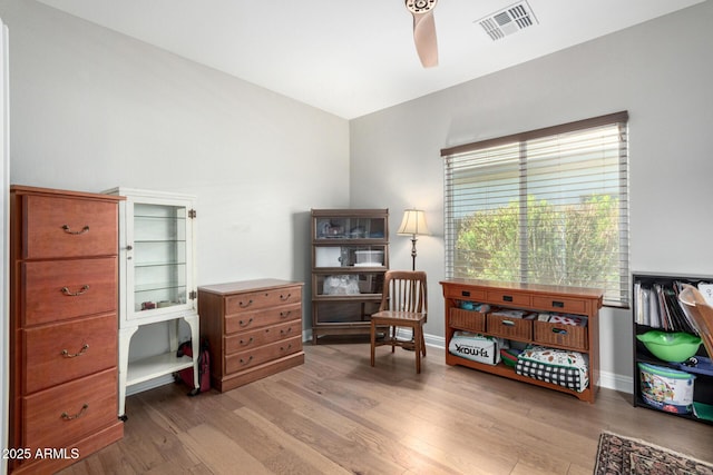 living area with light hardwood / wood-style floors and ceiling fan