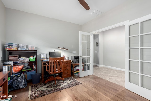 home office featuring wood-type flooring, ceiling fan, and french doors