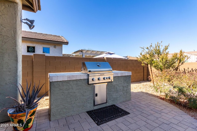 view of patio with area for grilling and a grill