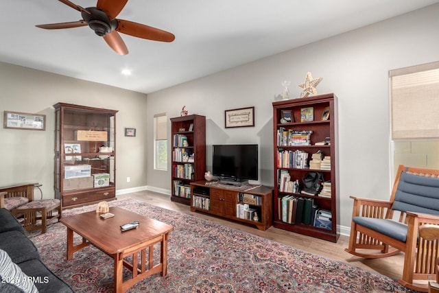 living room with ceiling fan and light hardwood / wood-style flooring