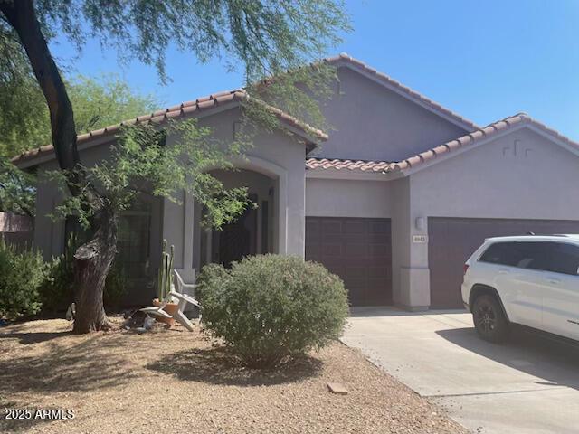 mediterranean / spanish-style home with a garage