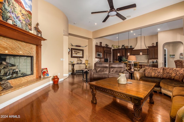 living room featuring ceiling fan, baseboards, dark wood-style floors, recessed lighting, and arched walkways