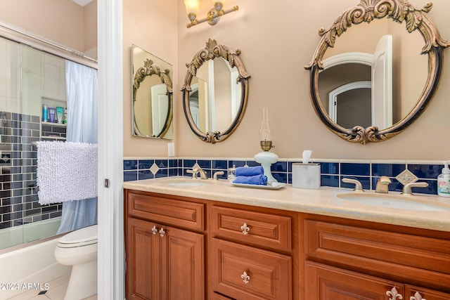 full bathroom with tile patterned flooring, double vanity, toilet, combined bath / shower with glass door, and decorative backsplash