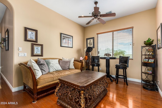 living room with visible vents, baseboards, wood finished floors, arched walkways, and a ceiling fan