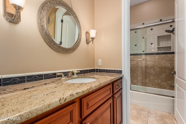 full bath featuring tile patterned flooring, vanity, and shower / bath combination with glass door