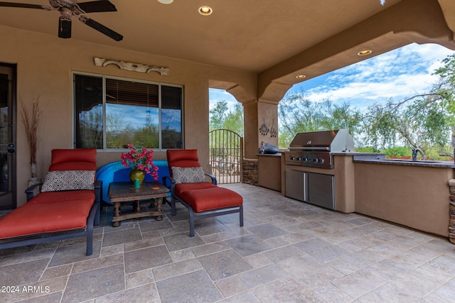 view of patio / terrace featuring a gate, a ceiling fan, area for grilling, a sink, and grilling area