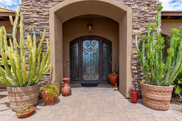 view of exterior entry with stone siding and stucco siding