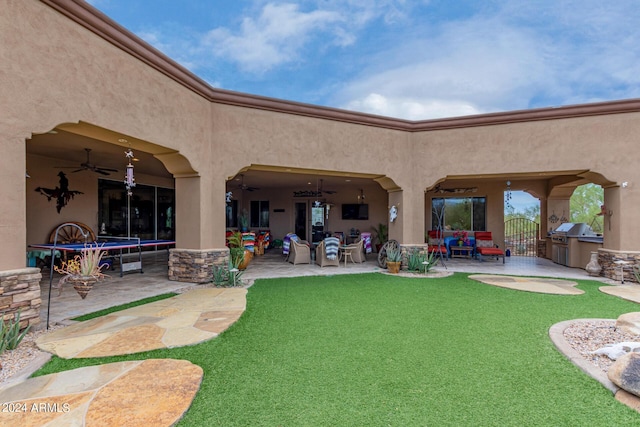 rear view of property featuring stucco siding, a ceiling fan, and a patio area