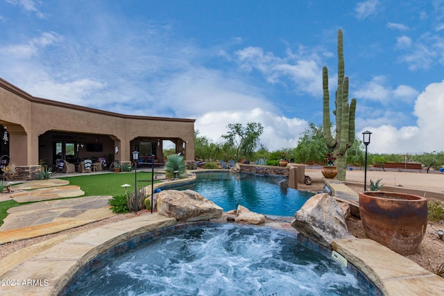 pool featuring a patio area and an in ground hot tub