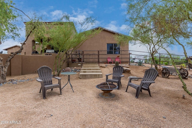 view of yard featuring a patio area, fence, and a fire pit