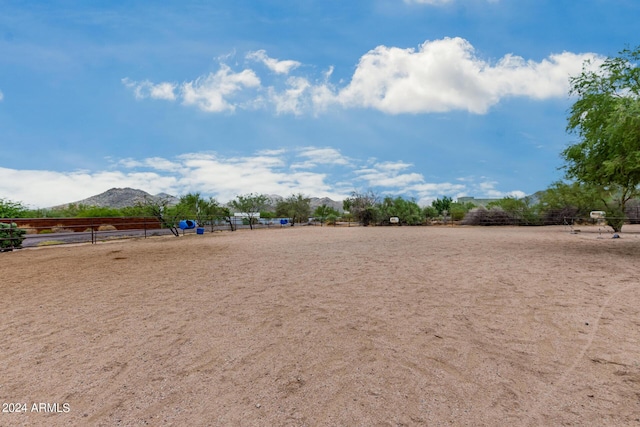 view of yard with an enclosed area, a rural view, and a mountain view