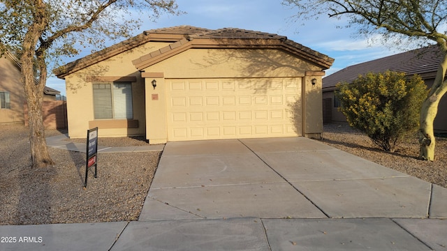 ranch-style house with driveway, an attached garage, a tile roof, and stucco siding