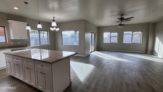 kitchen with plenty of natural light, a center island, dark hardwood / wood-style floors, and white cabinets