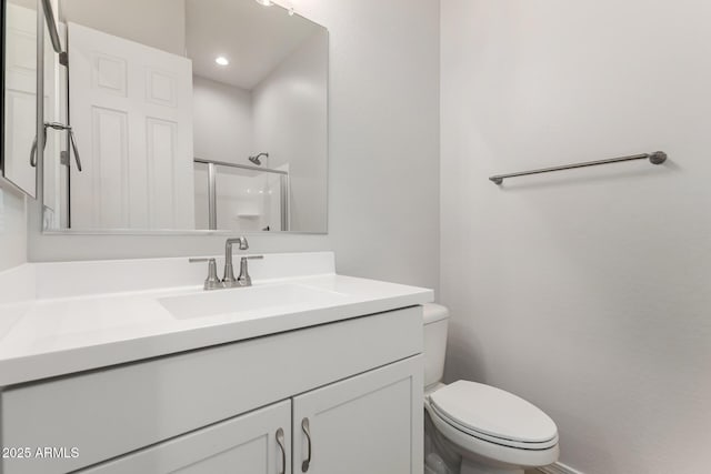 bathroom with toilet, an enclosed shower, and vanity