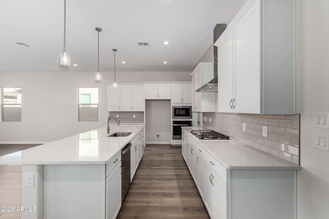 kitchen featuring white cabinets, appliances with stainless steel finishes, hanging light fixtures, and sink