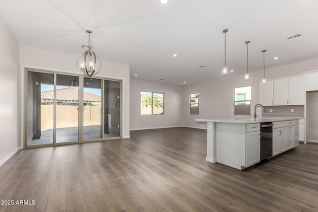 kitchen with white cabinetry, tasteful backsplash, pendant lighting, and a notable chandelier