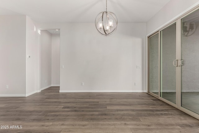 spare room featuring a notable chandelier and dark hardwood / wood-style floors