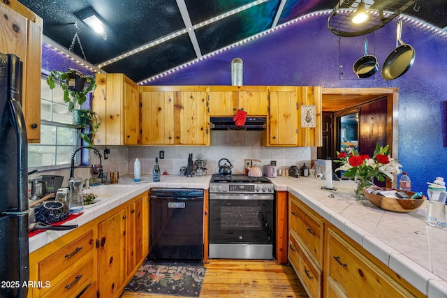 1326 W Apache Ln, Pinetop-Lakeside, AZ 85929 - kitchen with black appliances, under cabinet range hood, light wood-style flooring, tasteful backsplash, and lofted ceiling