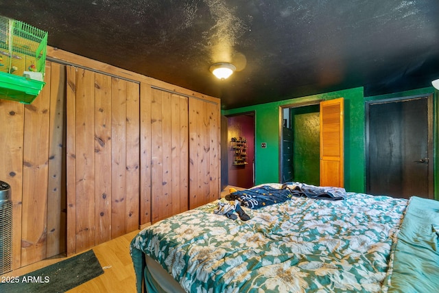 1326 W Apache Ln, Pinetop-Lakeside, AZ 85929 - bedroom with two closets, wood finished floors, and wooden walls