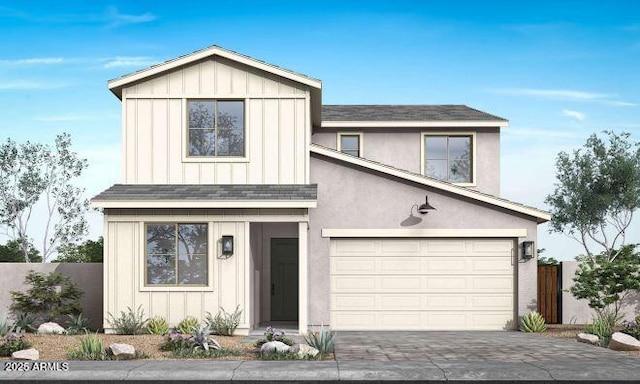 view of front of property featuring board and batten siding, decorative driveway, fence, and a garage