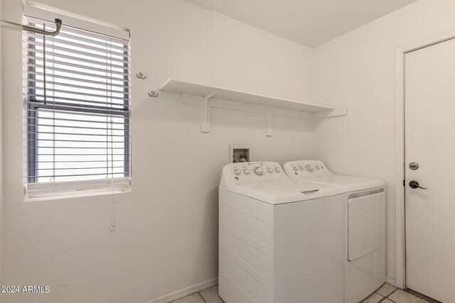 laundry area with separate washer and dryer, a wealth of natural light, and light tile patterned floors