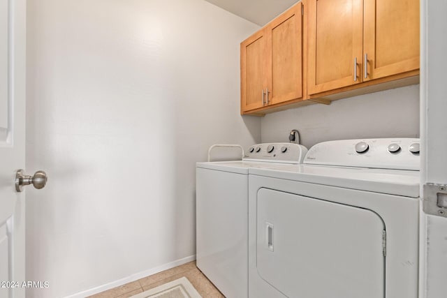 laundry area with light tile patterned flooring, cabinet space, baseboards, and washer and clothes dryer