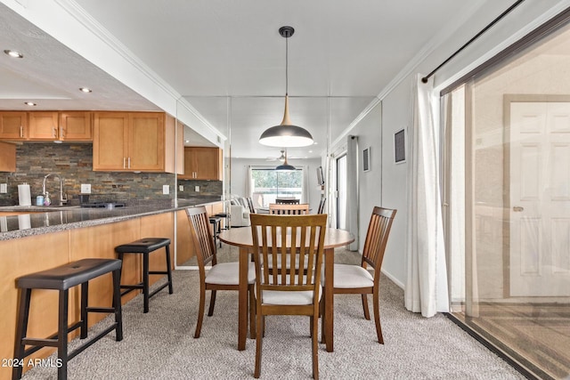 dining area featuring ornamental molding and light carpet