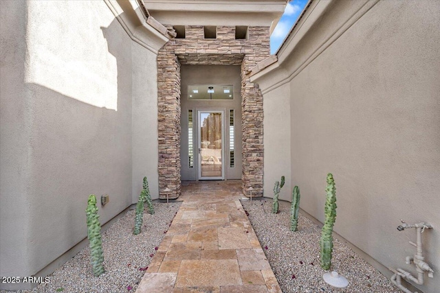 property entrance with stone siding and stucco siding