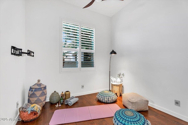 interior space featuring baseboards, wood finished floors, and a ceiling fan