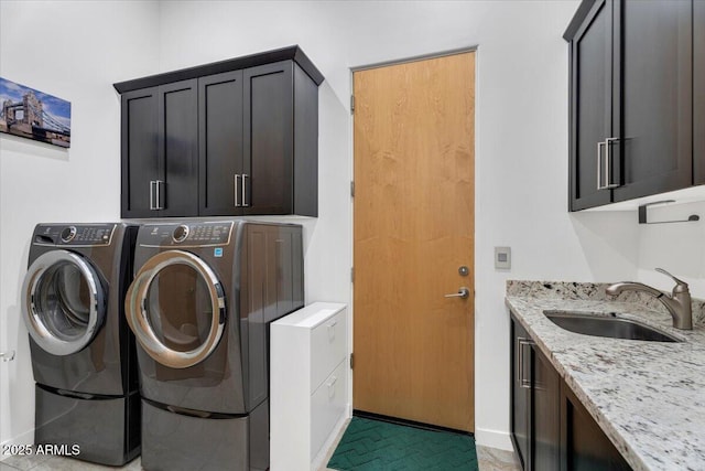 clothes washing area featuring a sink, cabinet space, and independent washer and dryer