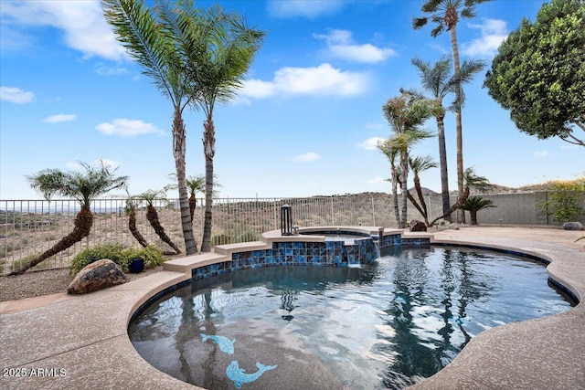 view of swimming pool featuring a fenced backyard and a pool with connected hot tub