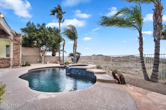 view of pool with a fenced backyard and a pool with connected hot tub